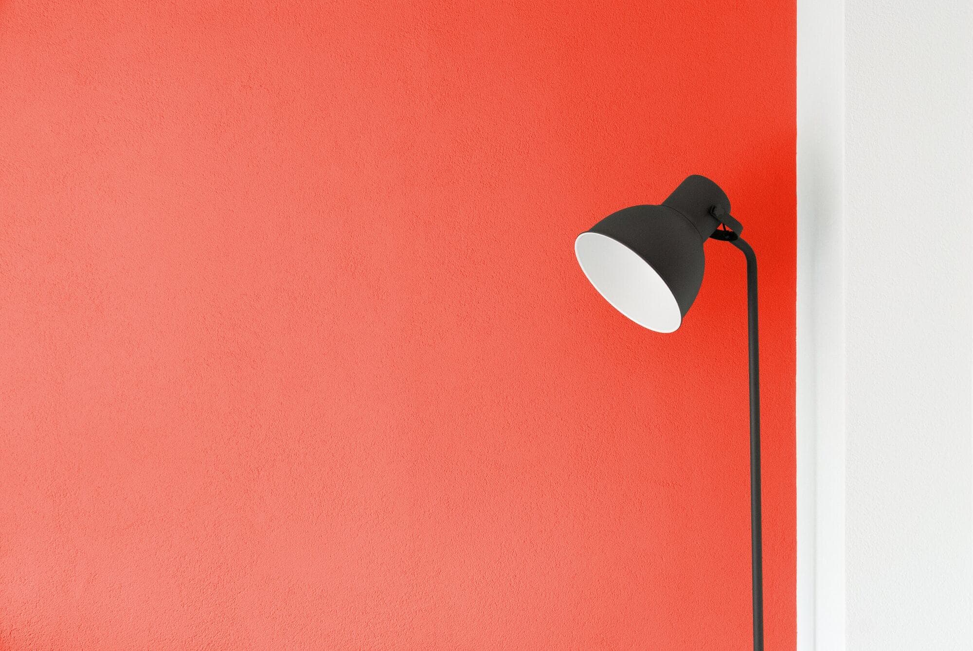 A dark lamp against a red wall